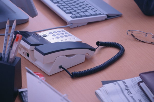 電話やPC、ペンなどが置かれているオフィスデスク