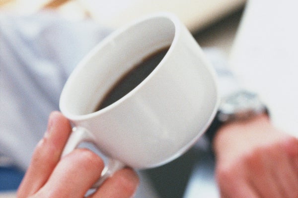 コーヒーカップを持つ男性の手