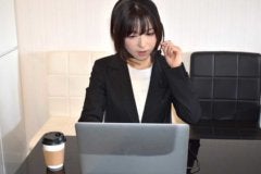 パソコンを見ながら電話対応する女性