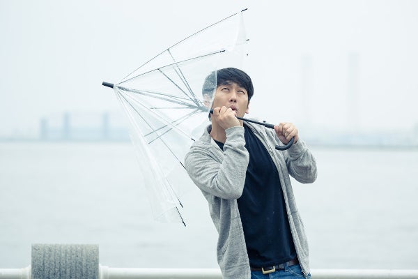 天気の悪い中、傘を指す男性