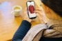 スマートフォンで服を見る女性