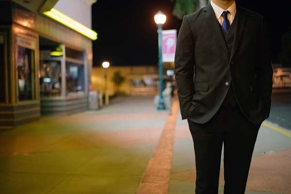 夜道を歩くスーツの男性